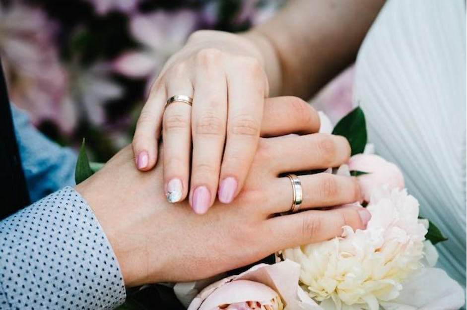 Sposi con fedi nuziali in oro bianco e oro rosa